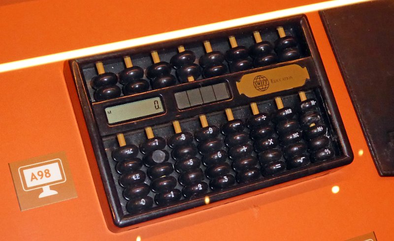 P1020106.JPG - An electronic handheld calculator designed as an abacus. Probably a business gadget distributed by the education branch of Swift International Financial Services.
