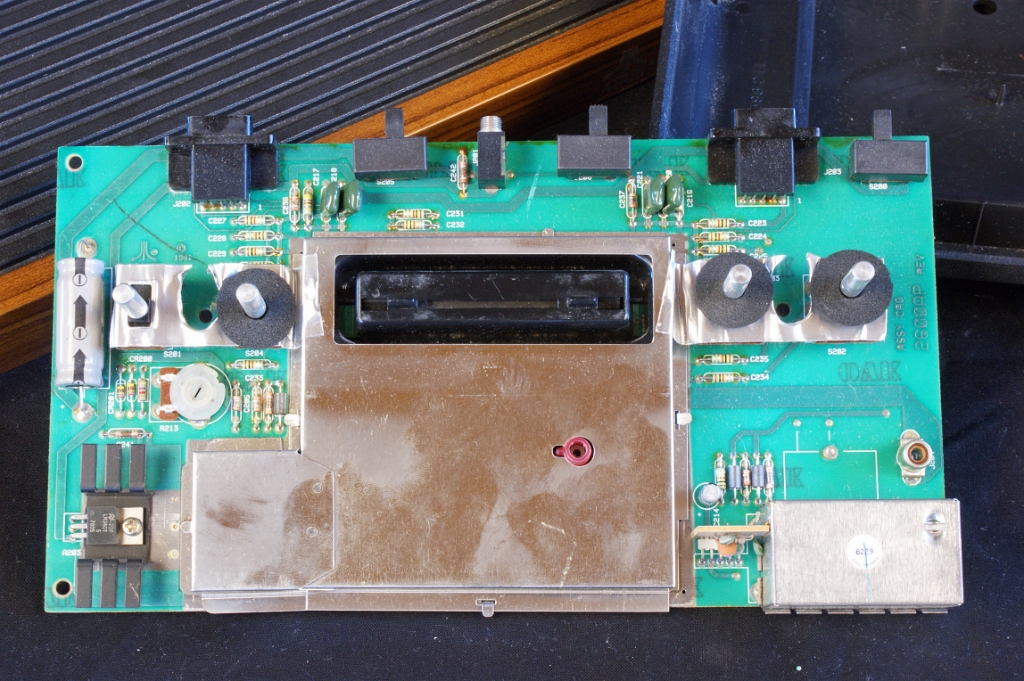 DSC03344.JPG - Close-up view on the good quality motherboard, which has expensive metallic shielding on both sides. This is a view on the upper side, showing the 3 sliding selectors on top and the 4 metallic switches located on both sides of the cartridge socket.