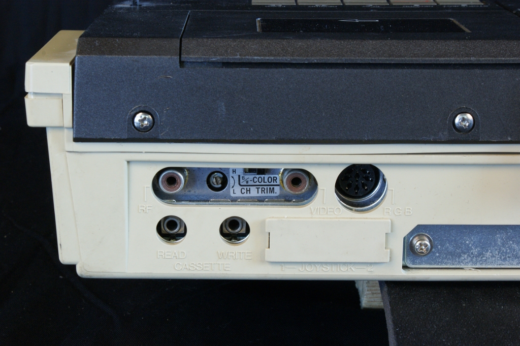 DSC03079.JPG - The two upper cinch sockets are the RF and Composite Video outputs, the DIN connector is the RGB output. There is a small trimmer to adjust the RF channel. The lower 3.5mm sockets are the Read/write connectors of an external tape recorder. The white plastic covers a joystick connector.