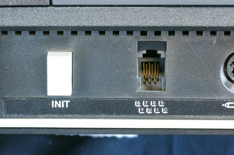 DSC02890.JPG - Close-up on Reset (Init) button and RJ type socket for keyboard cable.